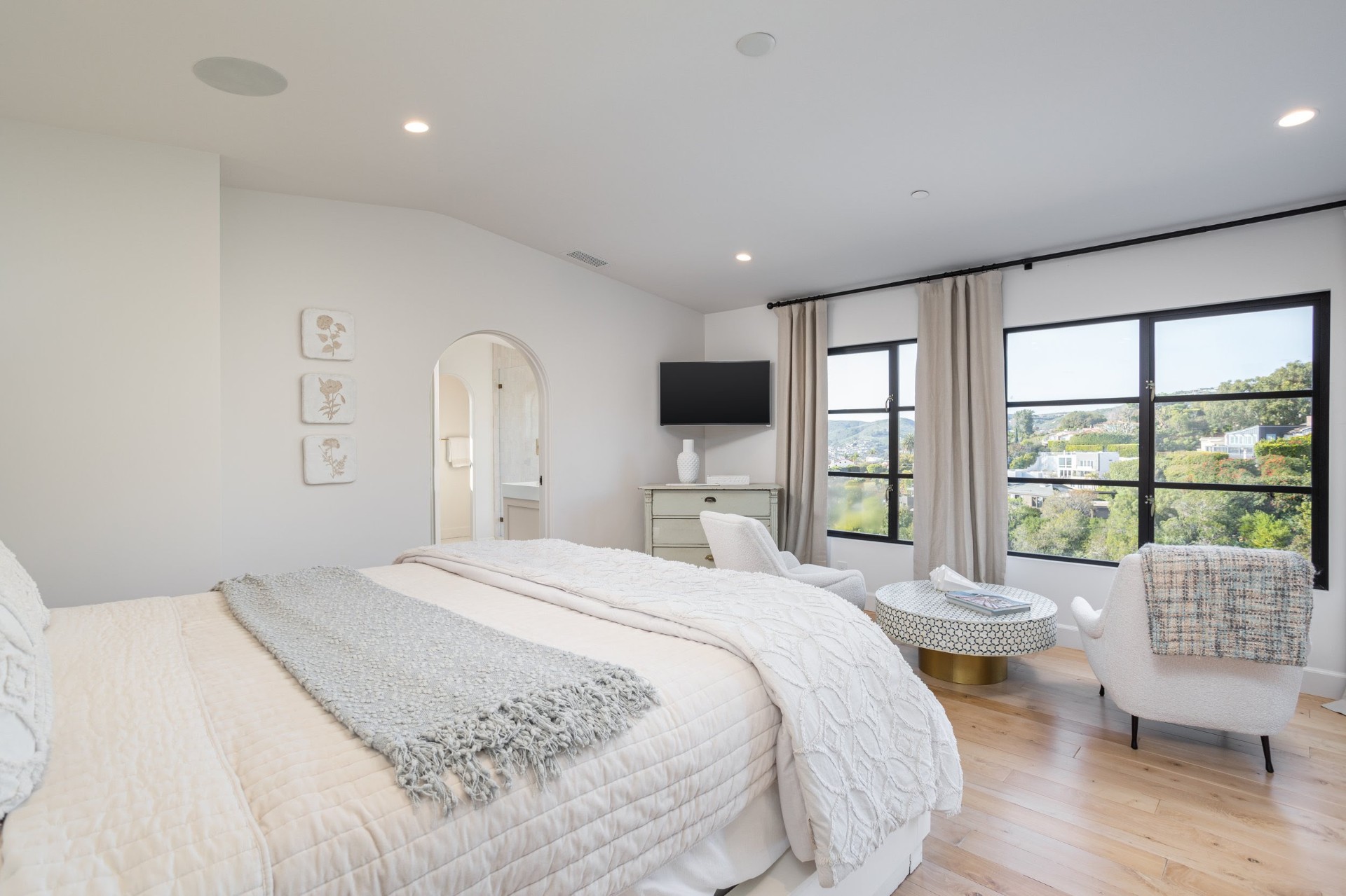 Primary bedroom in soft neutrals with ocean view